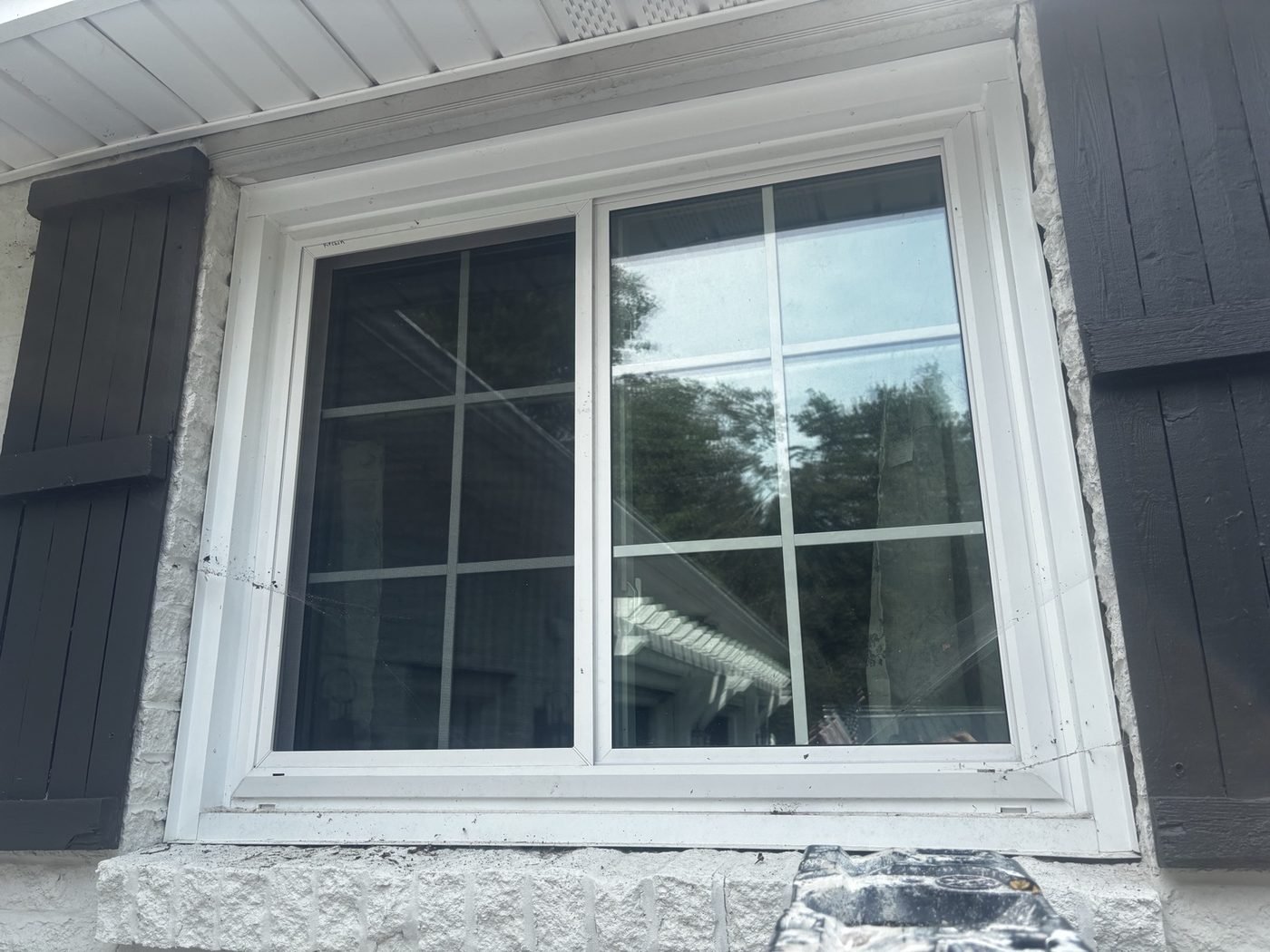 After — grid-pane slider window and stone sill